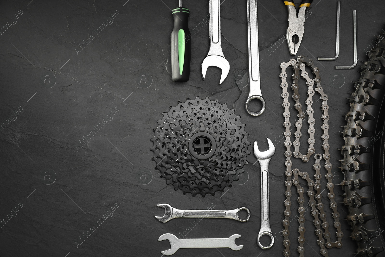 Photo of Parts of bicycle and tools on black table, flat lay. Space for text