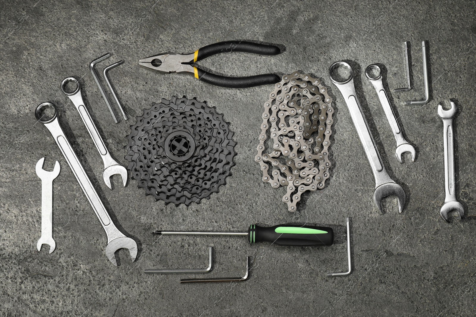 Photo of Parts of bicycle and tools on grey table, flat lay