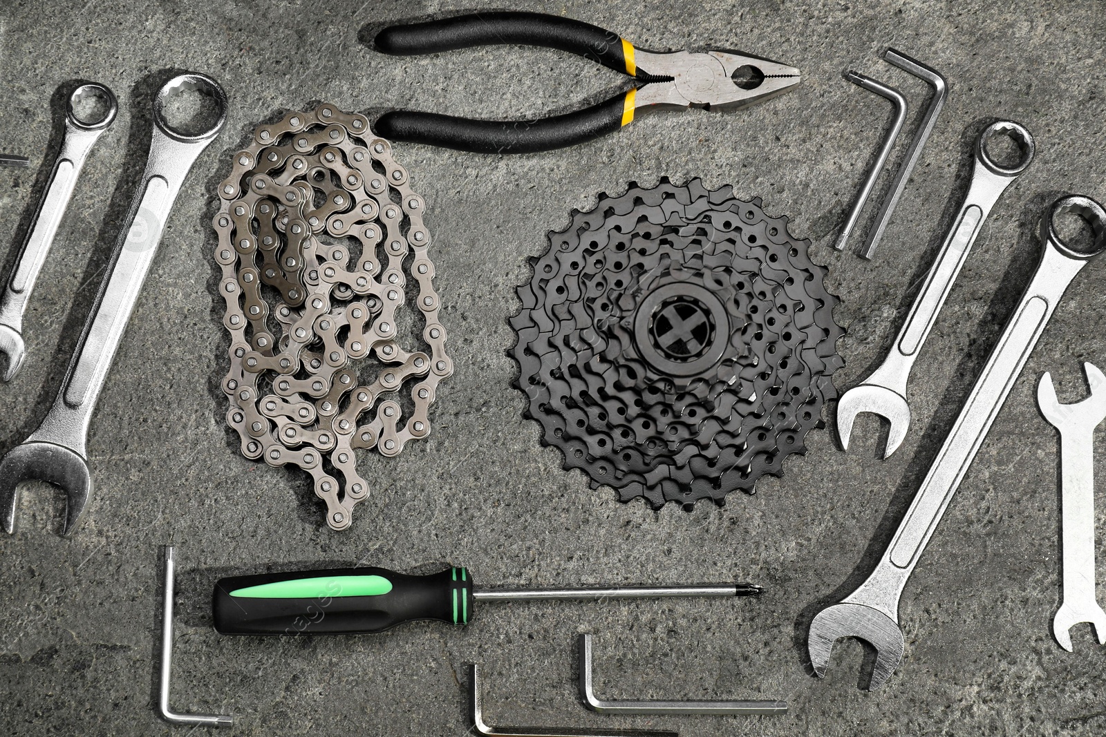 Photo of Parts of bicycle and tools on grey table, flat lay