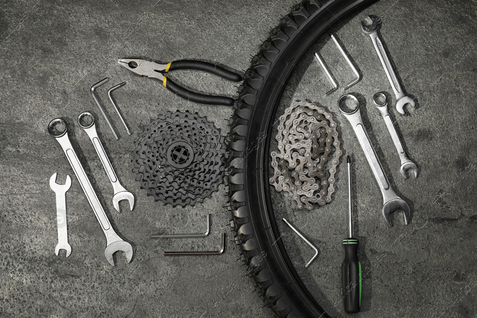 Photo of Parts of bicycle and tools on grey table, flat lay