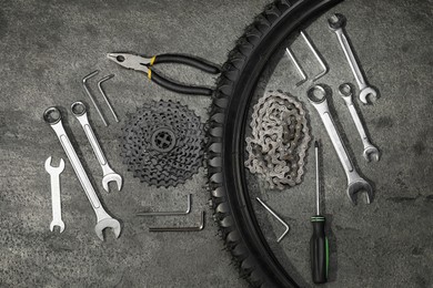 Photo of Parts of bicycle and tools on grey table, flat lay