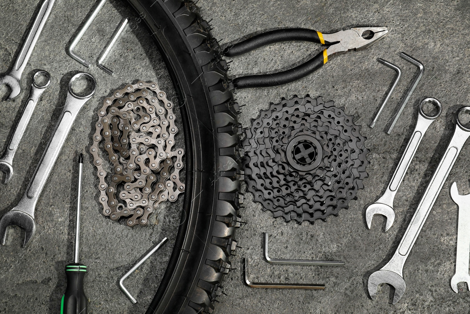 Photo of Parts of bicycle and tools on grey table, flat lay