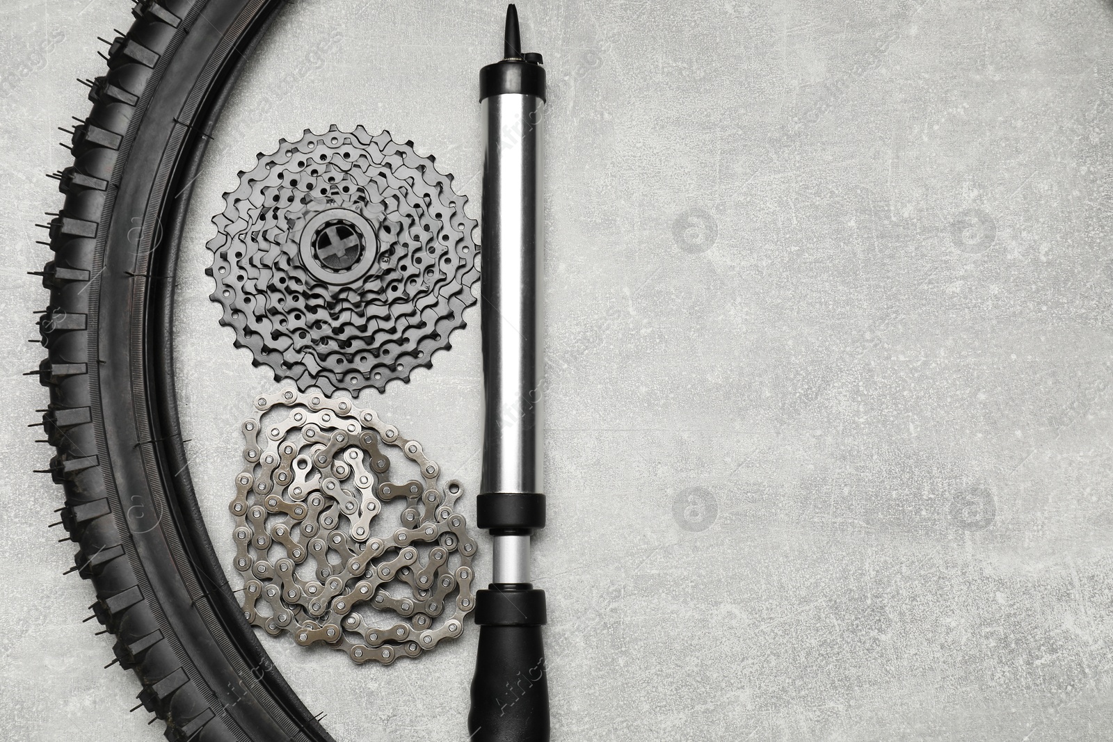 Photo of Parts of bicycle and tools on light grey table, flat lay. Space for text