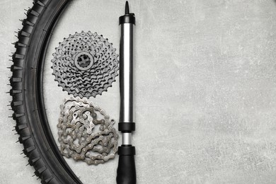 Parts of bicycle and tools on light grey table, flat lay. Space for text