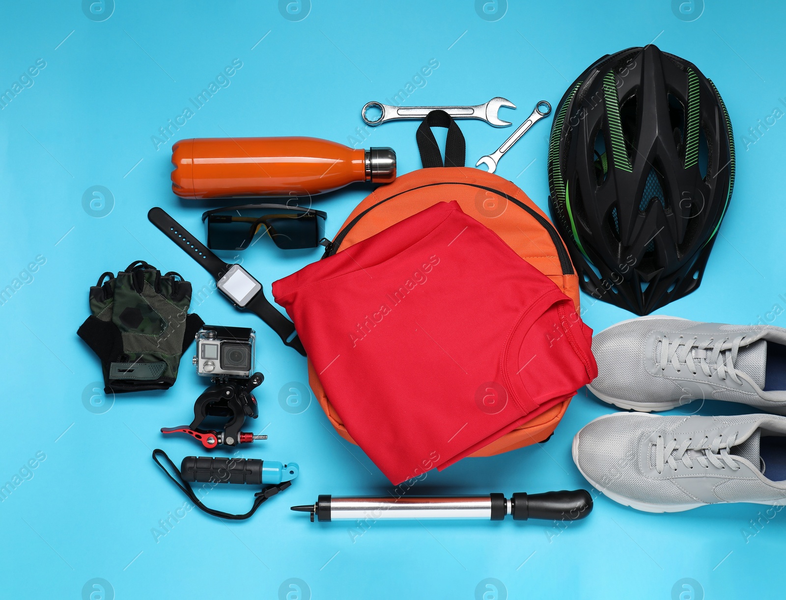 Photo of Bicycle accessories and equipment on light blue background, flat lay