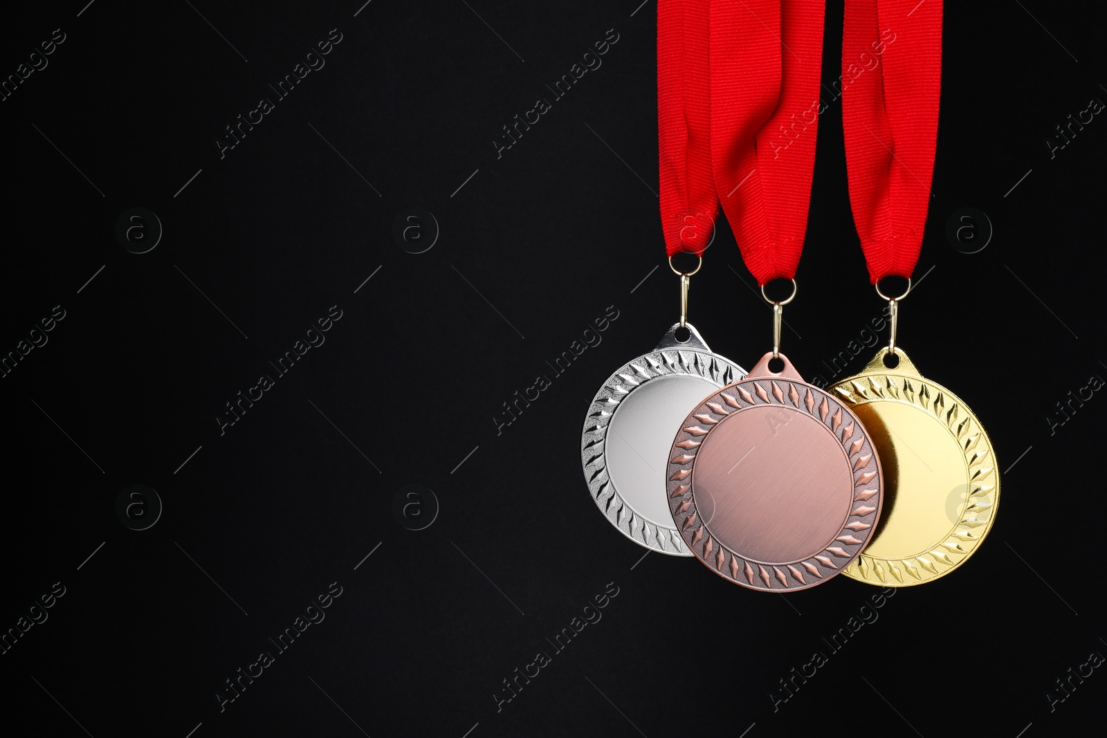 Photo of Golden, silver and bronze medals on black background, space for text