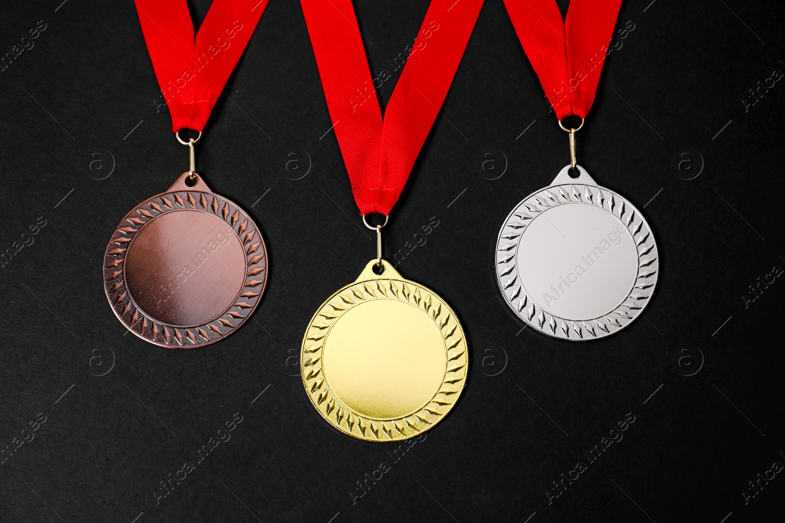 Photo of Golden, silver and bronze medals on black background, above view