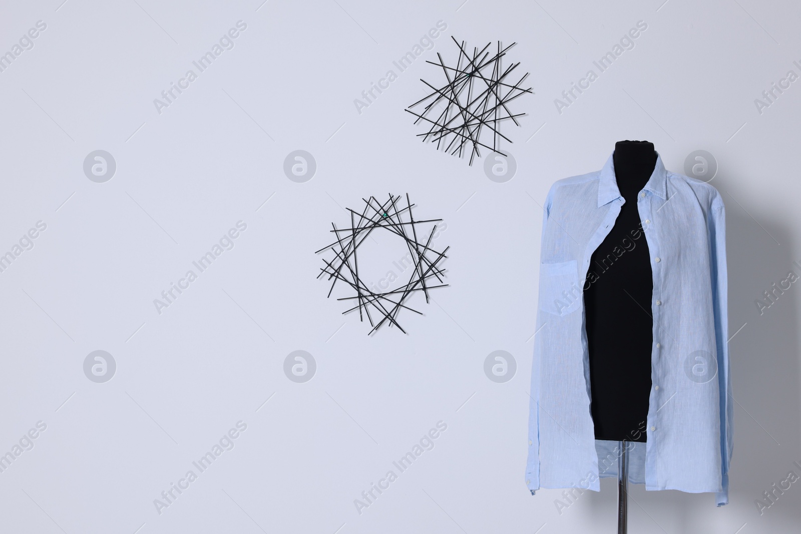 Photo of Female mannequin with stylish shirt near light wall, space for text