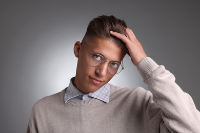 Photo of Handsome young man with stylish haircut on grey background