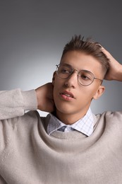 Photo of Handsome young man with stylish haircut on grey background