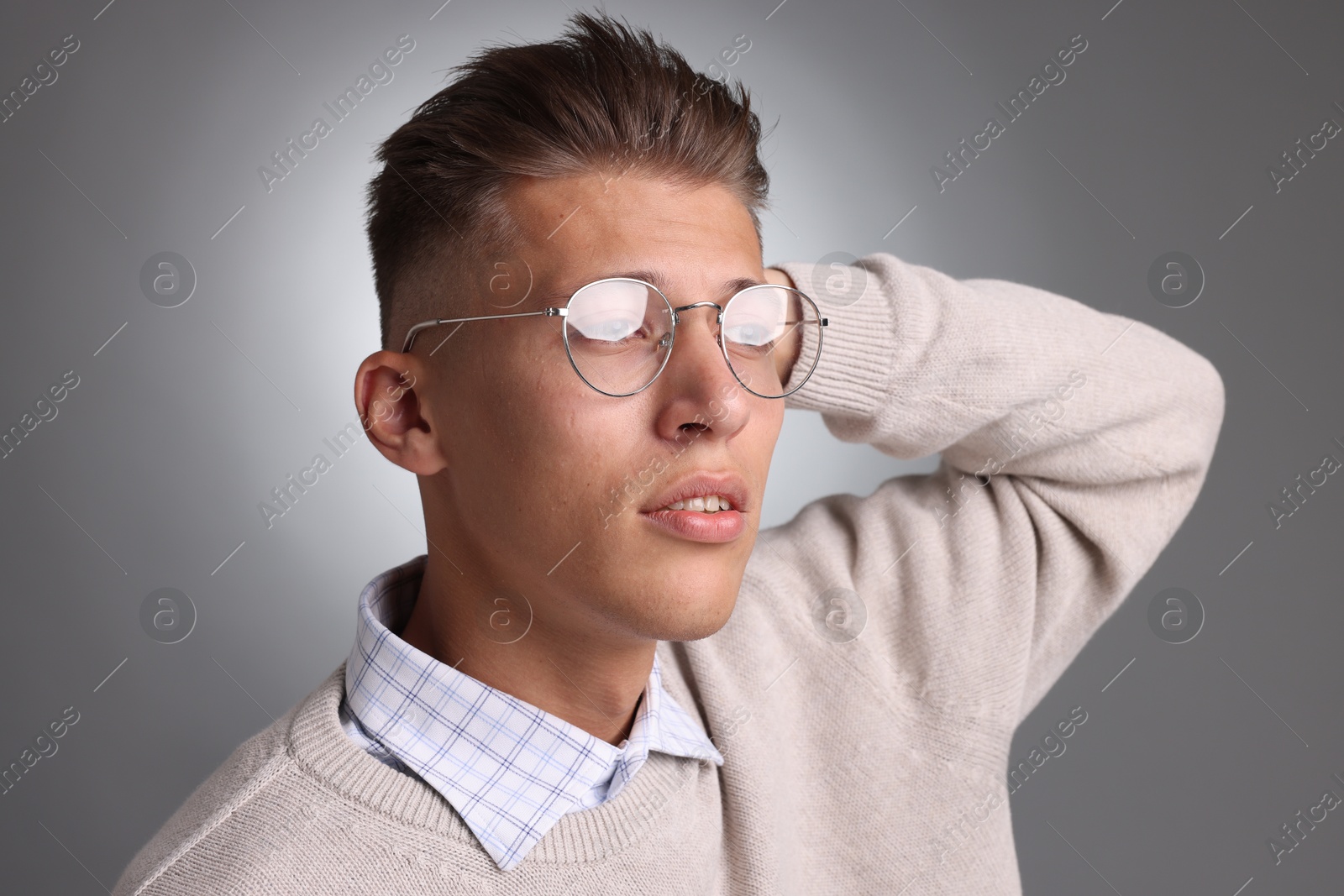 Photo of Handsome young man with stylish haircut on grey background