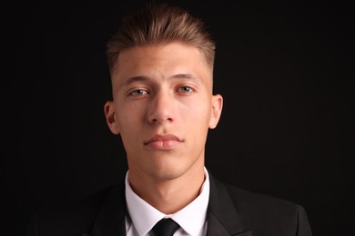 Photo of Confident young man with stylish haircut on black background