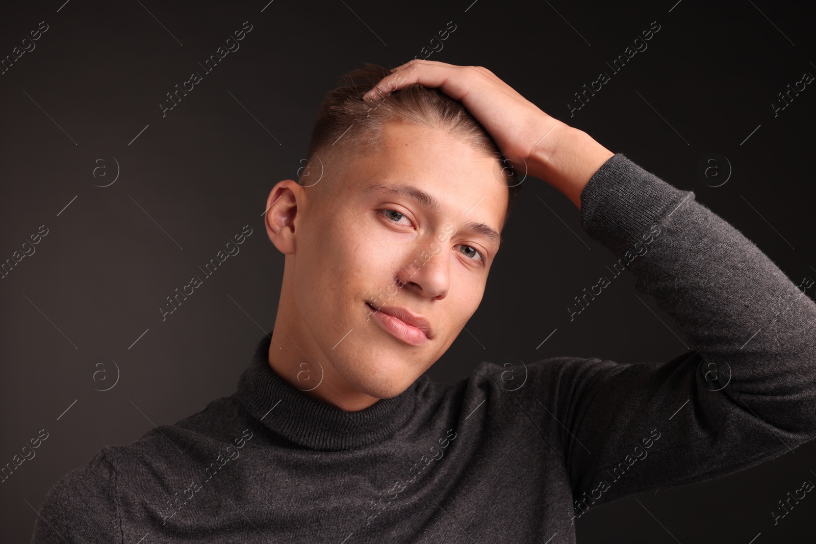 Photo of Confident young man with stylish haircut on black background