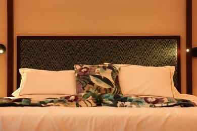 Photo of Comfortable bed with soft pillows in hotel room