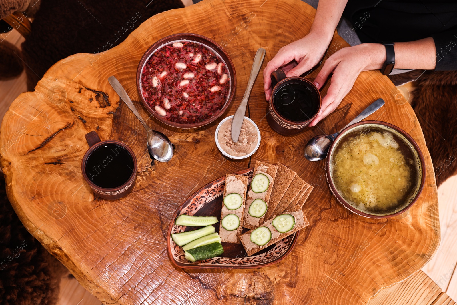 Photo of Woman with different dishes of Ukrainian cuisine at wooden table in cafe, top view