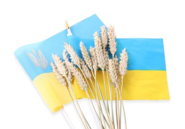 Ears of wheat and Ukrainian national flag isolated on white, top view