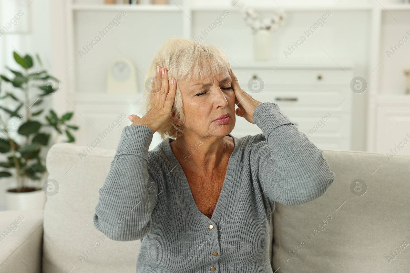 Photo of Beautiful senior woman suffering from headache at home