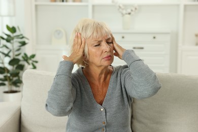 Photo of Beautiful senior woman suffering from headache at home