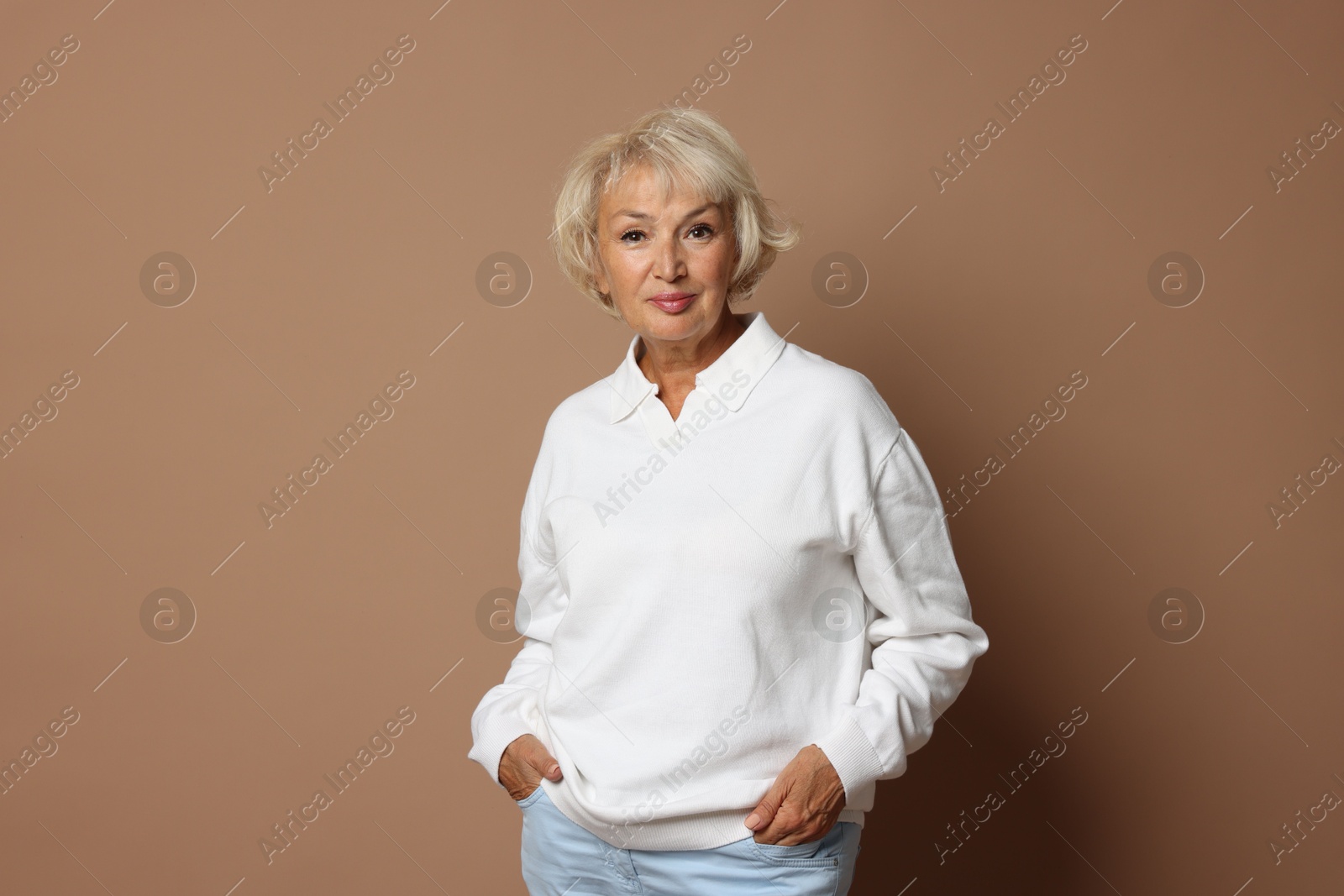 Photo of Portrait of beautiful senior woman on light brown background