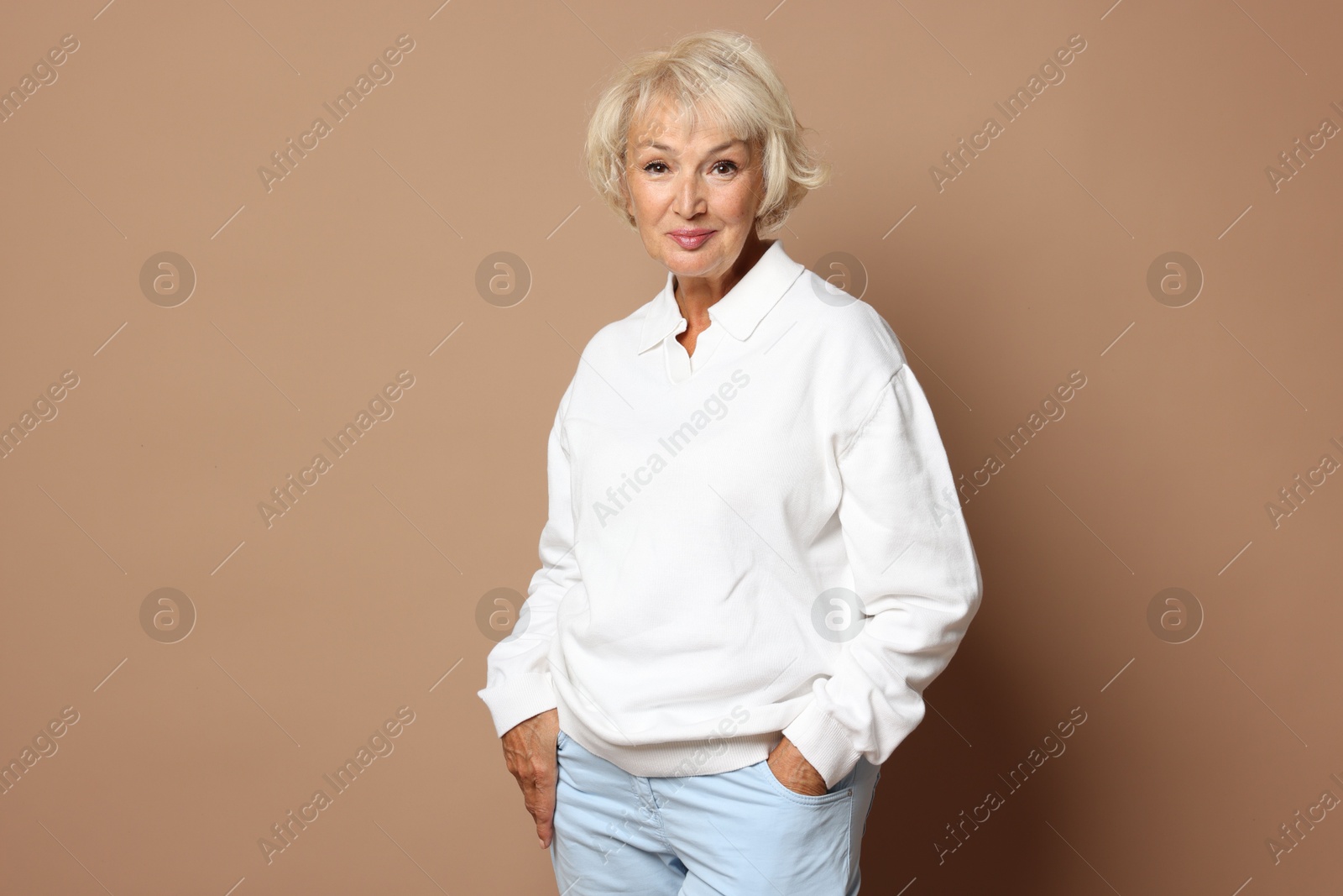 Photo of Portrait of beautiful senior woman on light brown background