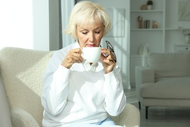 Photo of Beautiful senior woman with cup of drink at home