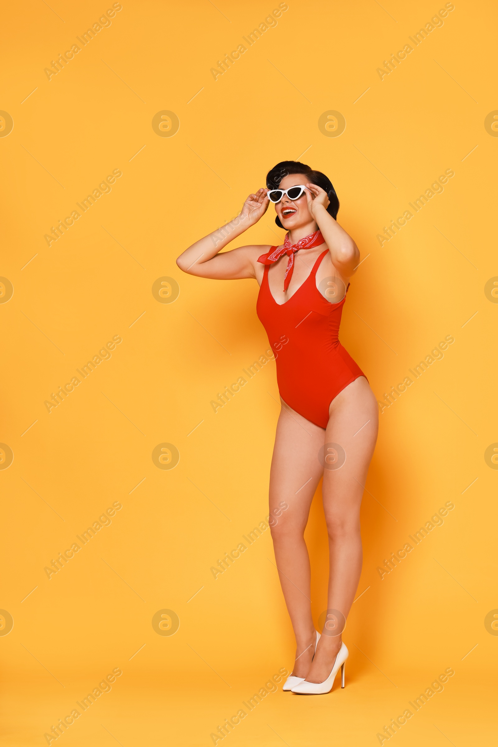 Photo of Pin-up woman in swimsuit on orange background