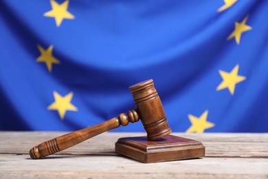 Photo of Judge's gavel on wooden table against European Union flag