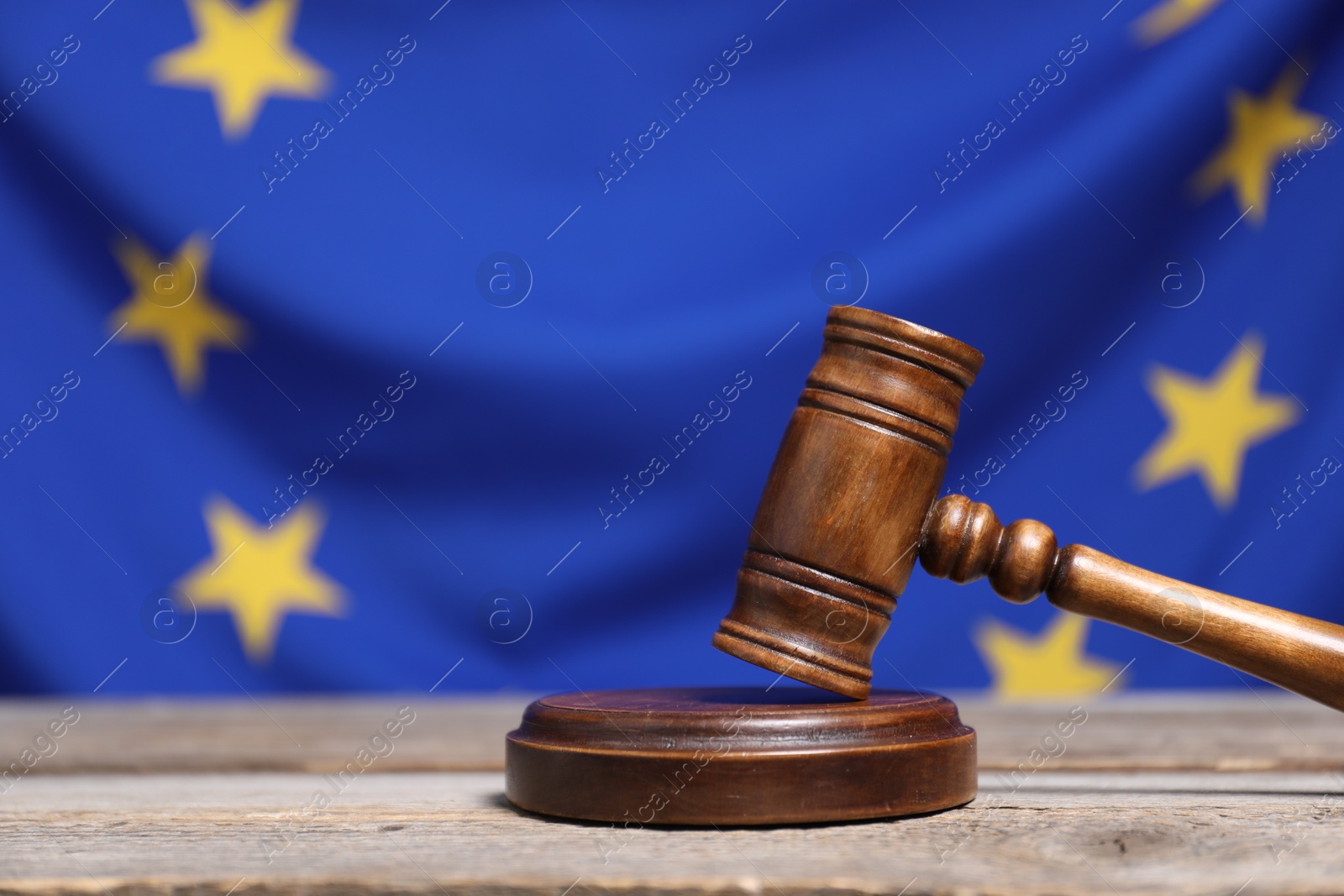 Photo of Judge's gavel on wooden table against European Union flag, space for text