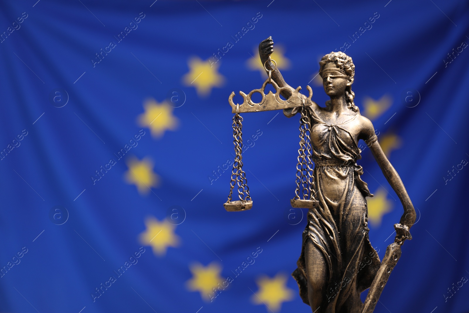 Photo of Figure of Lady Justice against European Union flag, closeup. Space for text