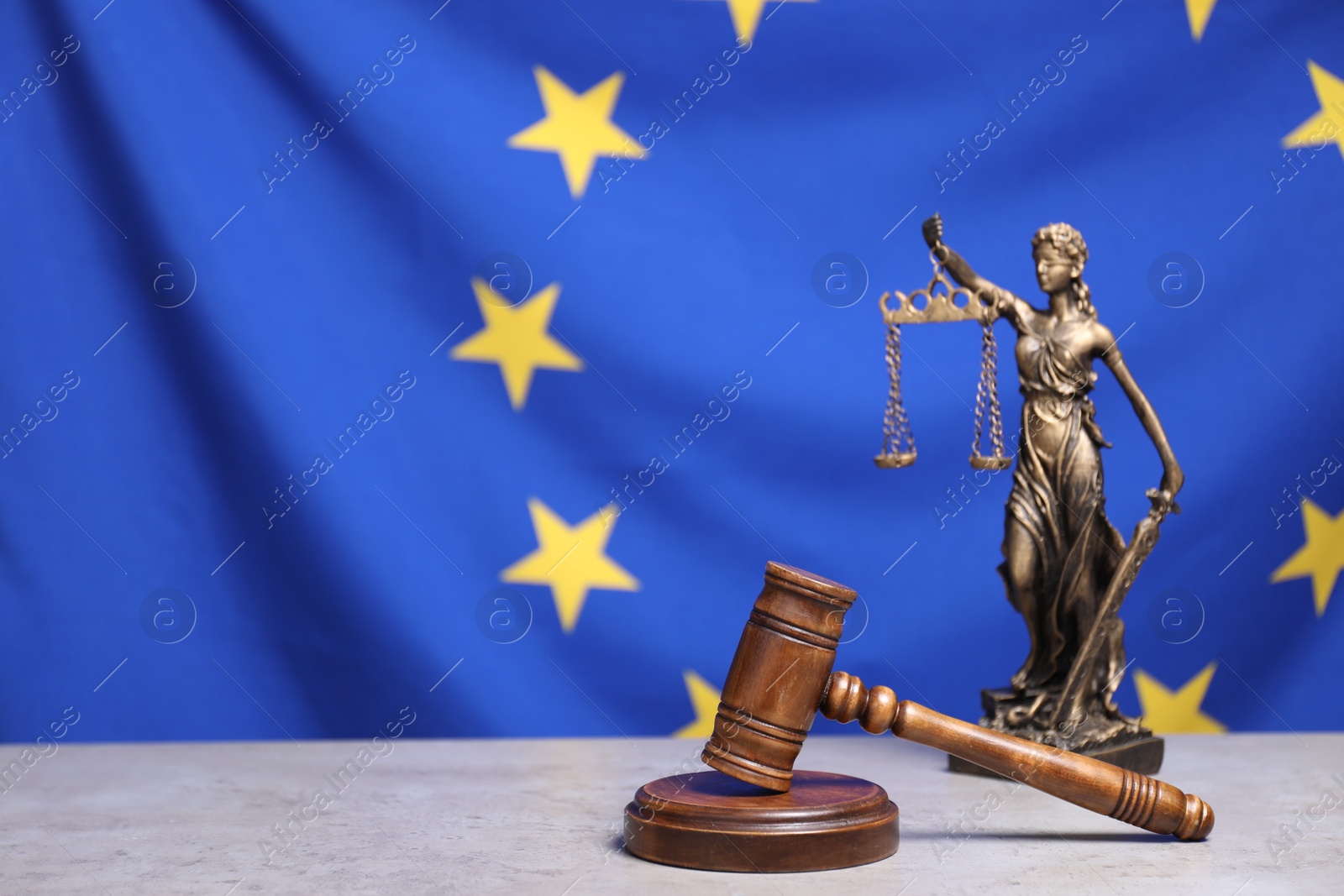 Photo of Figure of Lady Justice and judge's gavel on table against European Union flag, space for text