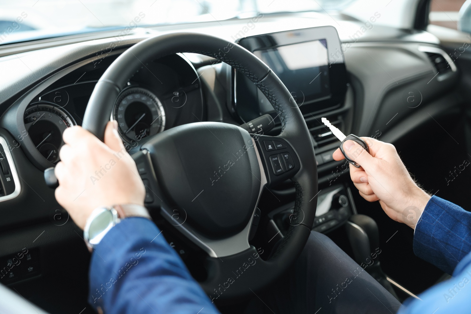 Photo of Man with key inside new car in salon, closeup