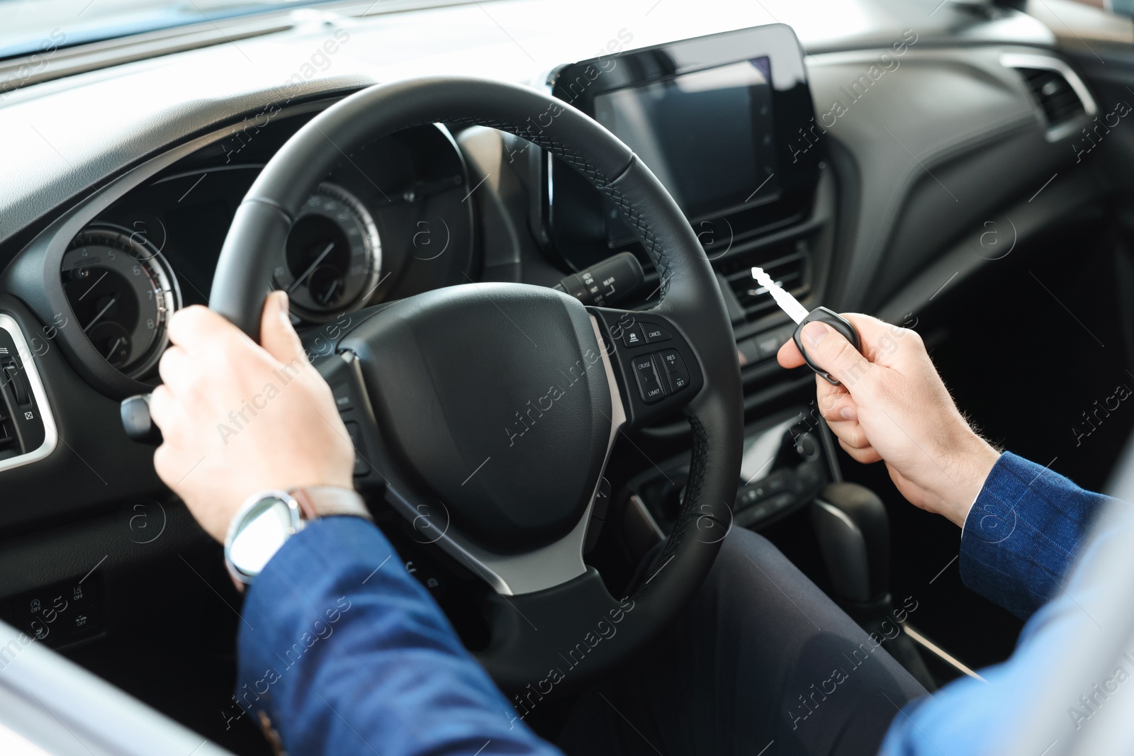 Photo of Man with key inside new car in salon, closeup