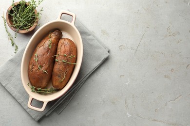 Photo of Tasty cooked sweet potatoes served with thyme on light grey table, flat lay. Space for text