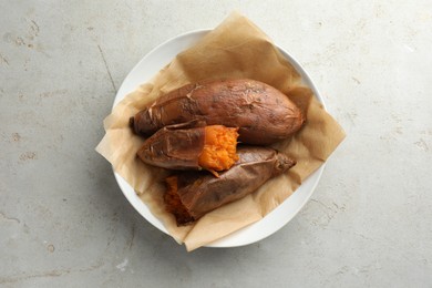 Photo of Tasty cooked sweet potatoes served on light grey table, top view