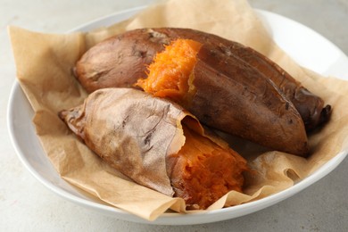 Tasty cooked sweet potatoes served on light grey table, closeup