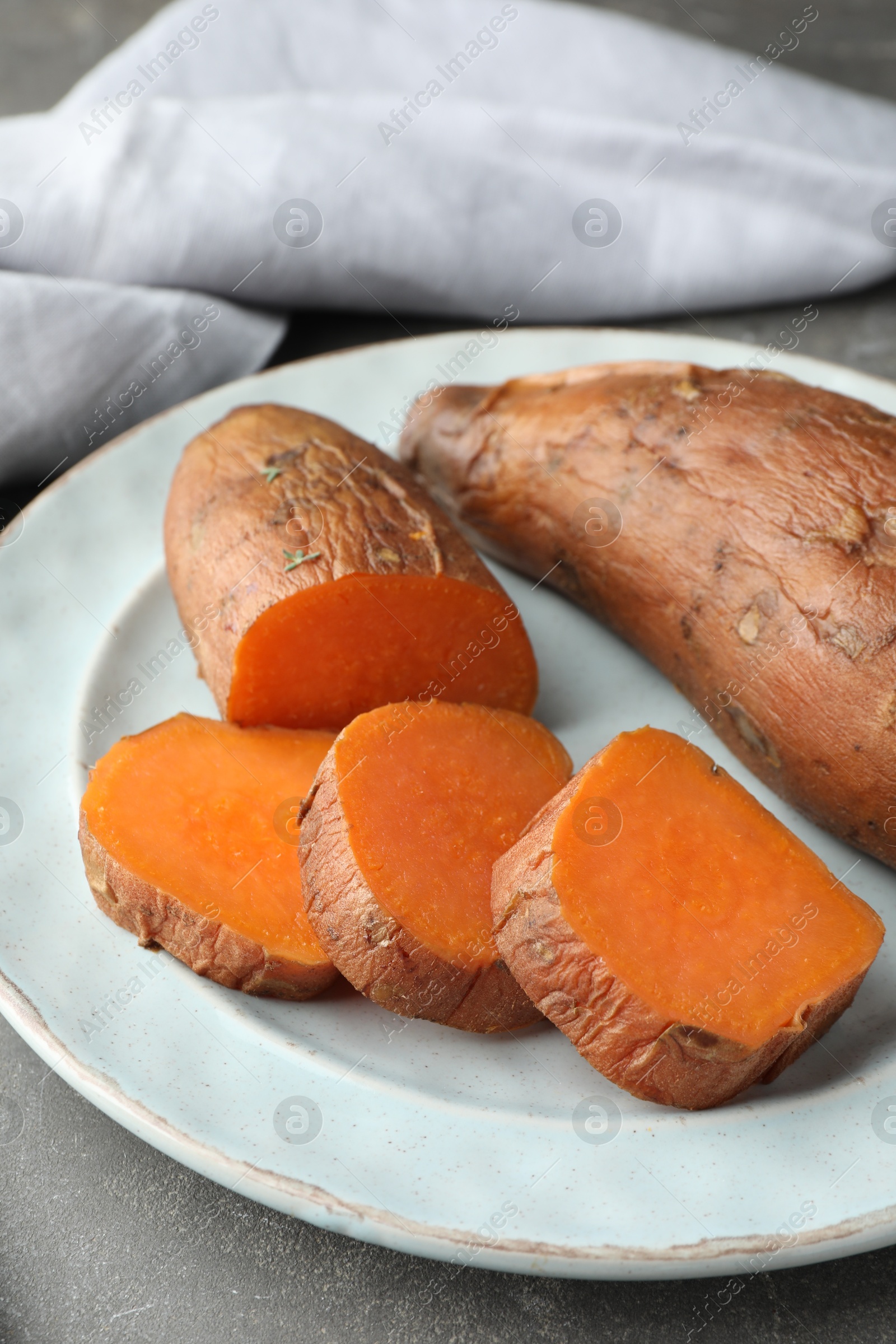 Tasty cooked sweet potatoes served on grey table, closeup Photo of Tasty cooked sweet potatoes served on grey table, closeup