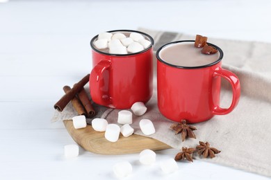 Photo of Yummy cocoa with marshmallows and spices on white wooden table