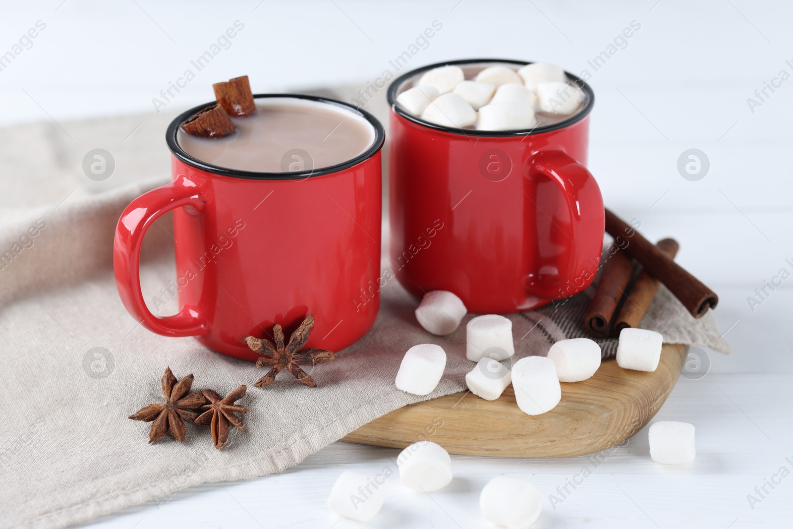 Photo of Yummy cocoa with marshmallows and spices on white wooden table