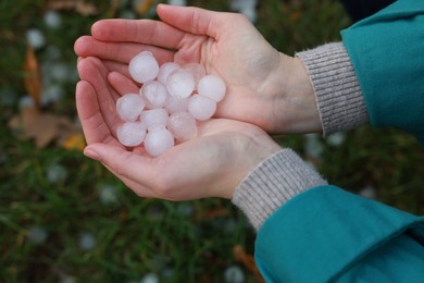 Photo of Woman holding hail grains after thunderstorm outdoors, top view