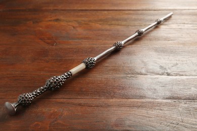 Photo of One old magic wand on wooden table, closeup