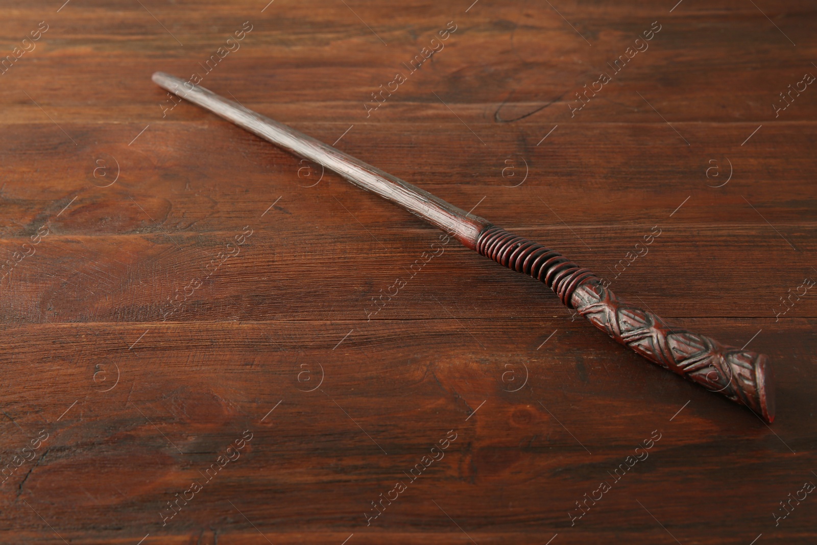 Photo of One old magic wand on wooden table, closeup