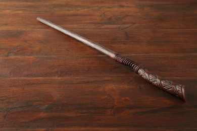 Photo of One old magic wand on wooden table, closeup