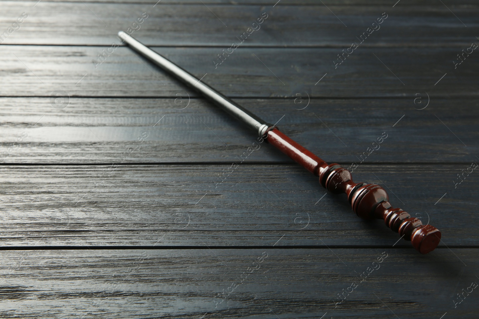 Photo of One old magic wand on wooden table, closeup