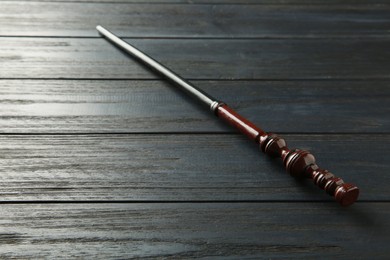 Photo of One old magic wand on wooden table, closeup