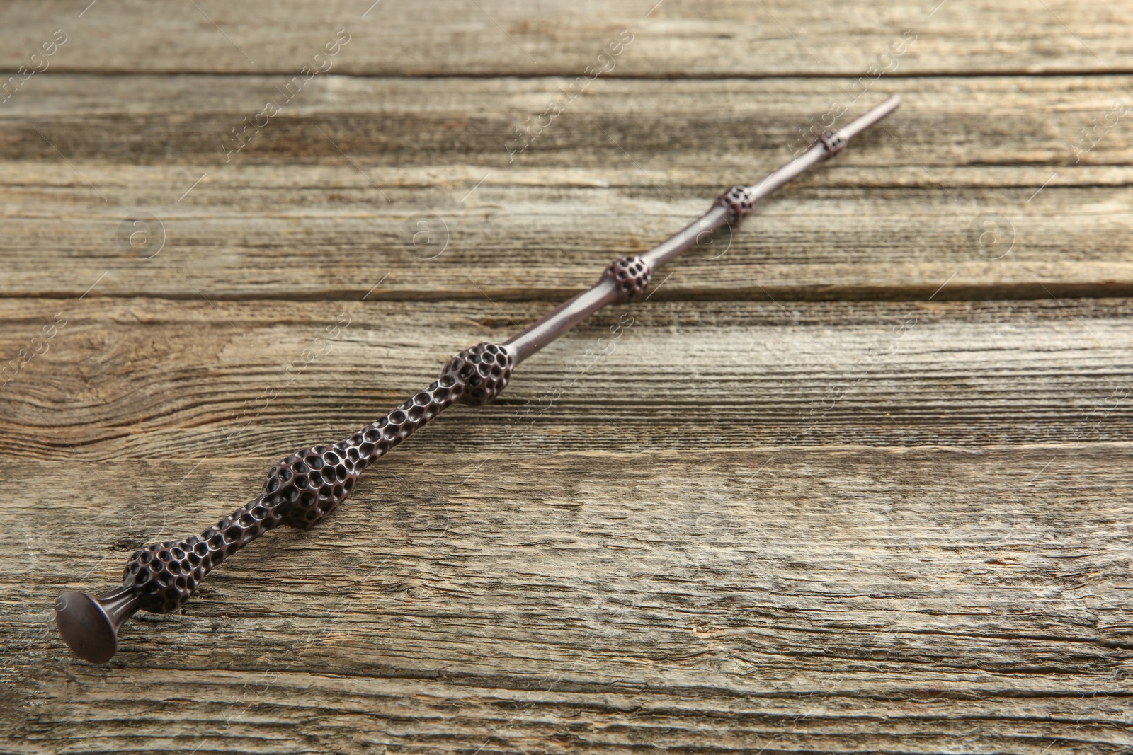 Photo of One magic wand on wooden table, closeup