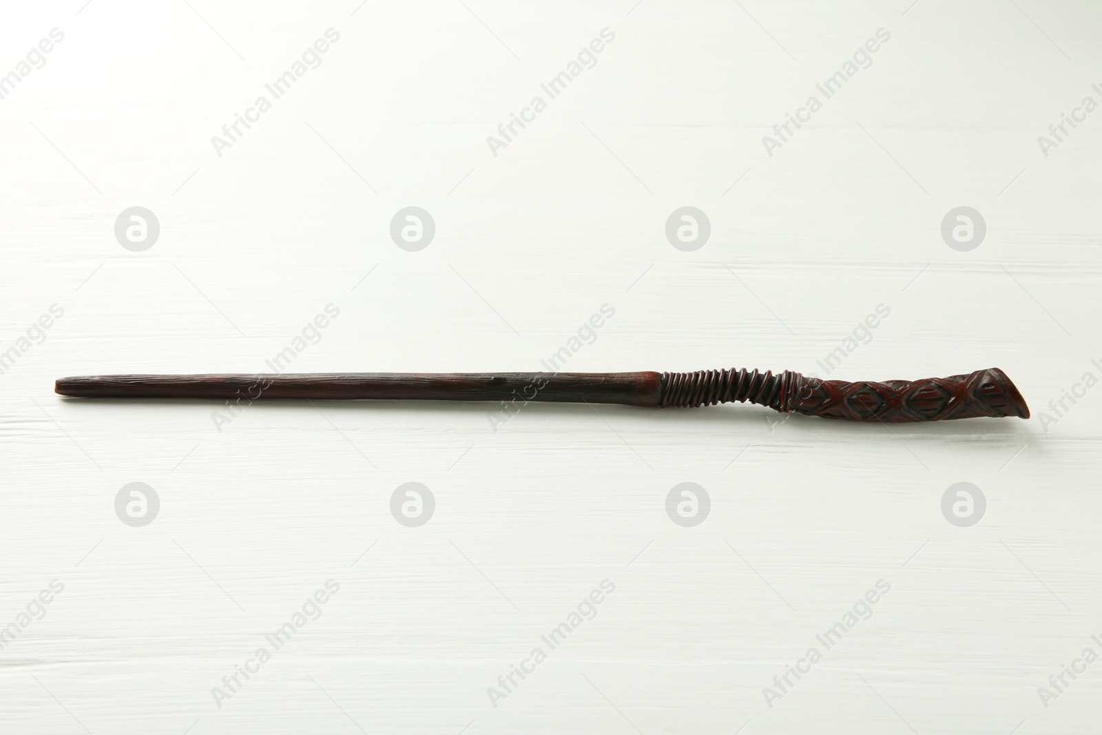 Photo of One old magic wand on white wooden table