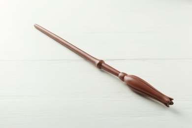 Photo of One old magic wand on white wooden table, closeup