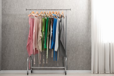 Photo of Aprons on clothing rack near light grey wall