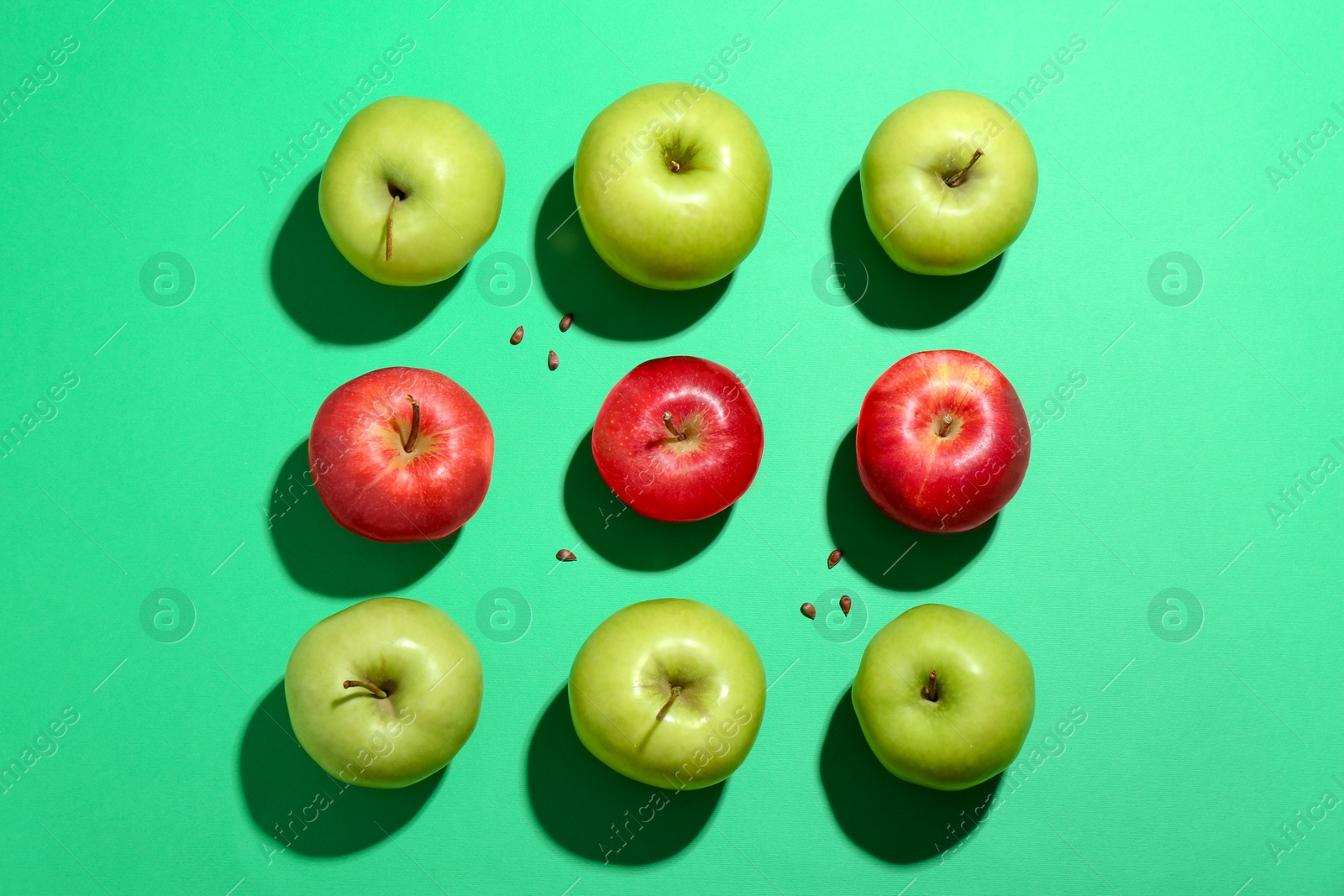 Photo of Flat lay composition with different apples and seeds on green background