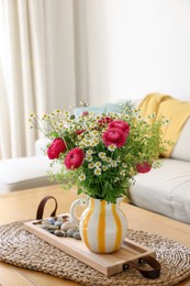 Photo of Beautiful ranunculus flowers and chamomiles in vase on table indoors